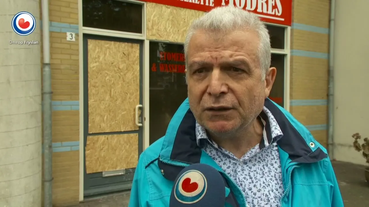 Ali Sepet voor de dichtgetimmerde winkel na de brand